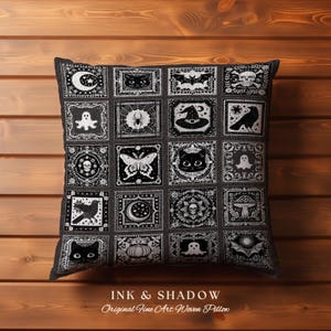 May include: Black and white pillow with a patchwork design featuring various Halloween-themed illustrations, including bats, ghosts, spiders, cats, and moons. The pillow reads "INK & SHADOW Original Fine Art Woven Pillow".
