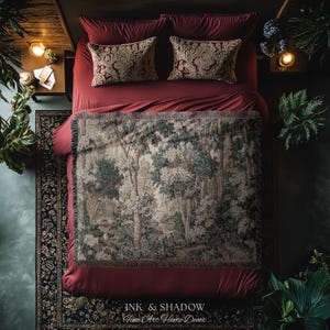 May include: A bed with burgundy bedding, two patterned throw pillows, and a forest scene throw blanket. The blanket features a detailed depiction of trees and foliage in shades of green, gray, and white. The image includes the text "INK & SHADOW Fine Art Home Decor".