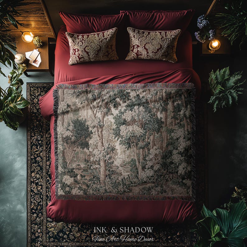 May include: A bed with burgundy bedding, two patterned throw pillows, and a forest scene throw blanket. The blanket features a detailed depiction of trees and foliage in shades of green, gray, and white. The image includes the text "INK & SHADOW Fine Art Home Decor".