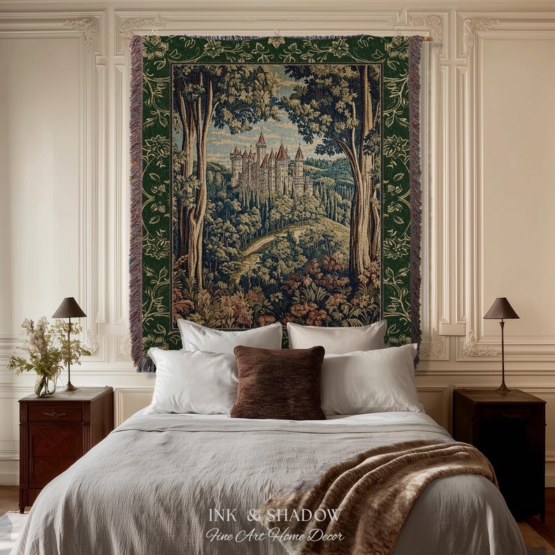 May include: A woven wall tapestry featuring a detailed landscape scene of a castle nestled among trees. The tapestry has a dark green floral border and fringed edges. The central image depicts a stone castle on a hill surrounded by a forest.