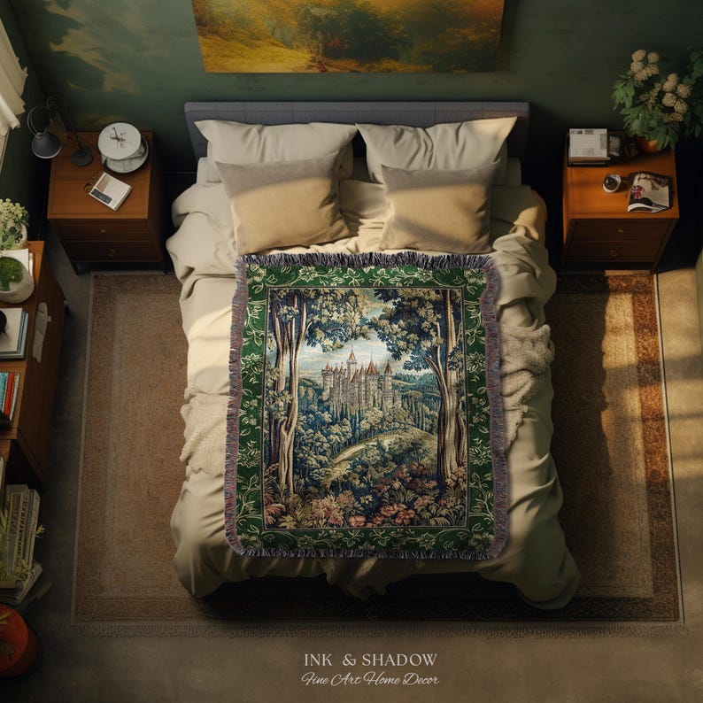 May include: A rectangular woven throw blanket featuring a detailed tapestry-style scene of a castle nestled within a dense forest. The blanket has a dark green border with intricate patterns and a fringed edge, displayed flat on a bed.
