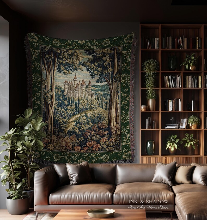May include: A woven wall tapestry featuring a detailed landscape scene of a castle nestled within a dense forest. The artwork is framed by a dark green border with floral patterns and includes the text Ink & Shadow Fine Art Home Decor.