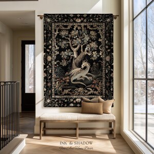 May include: A rectangular wall tapestry featuring a central illustration of a light-colored dragon resting beneath a large tree, surrounded by floral motifs on a black background, all enclosed within a decorative border and hung on a metal rod.