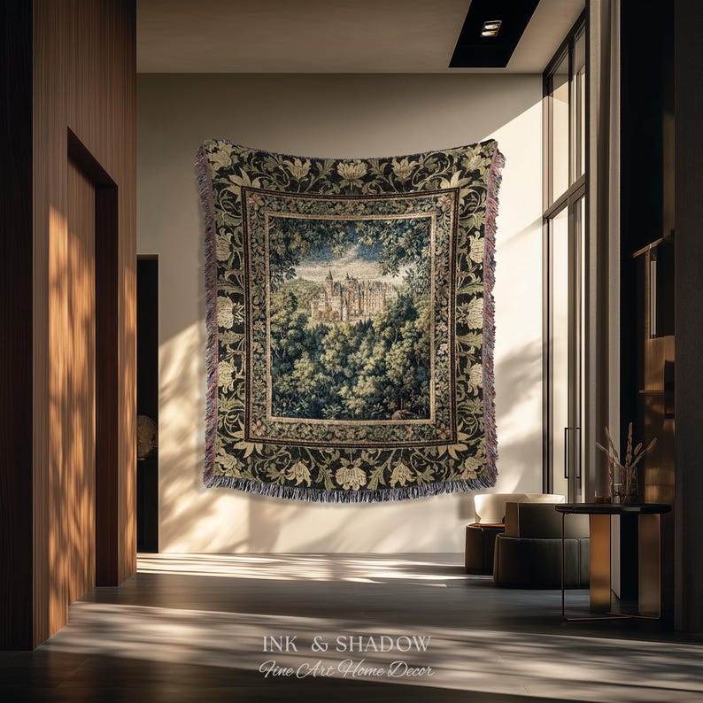 May include: A rectangular woven tapestry featuring a detailed landscape scene of a castle surrounded by dense green trees. The central image is framed by a dark border with floral patterns and has fringed edges on all four sides.