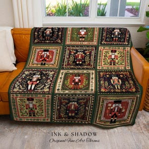Puede incluir: Una manta verde con un patrón repetido de figuras de cascanueces en rojo, negro y dorado. La manta está sobre un sofá de cuero marrón. El texto "INK & SHADOW Original Fine Art Throws" está en la parte inferior.