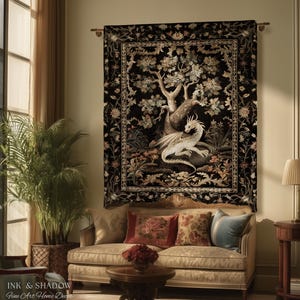 May include: A rectangular wall tapestry featuring a white dragon resting beneath a large tree against a black background, surrounded by a detailed floral border. The artwork is mounted on a horizontal rod and displays the text Ink & Shadow.
