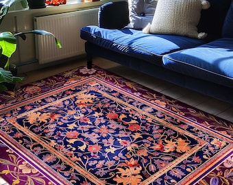 May include: A rectangular area rug with a dark blue central field, featuring a floral pattern in shades of orange and red. The rug has a deep purple border with floral designs and is placed on a wooden floor. The text "INK & SHADOW Original Fine Art Rugs" is visible.