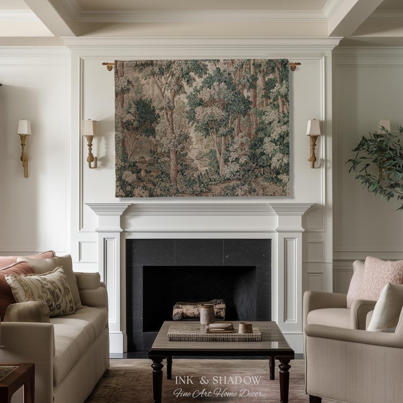 May include: A living room with a forest tapestry above a fireplace. The tapestry features a detailed forest scene in shades of green, brown, and beige. The room includes a sofa, chairs, and a coffee table. The text "INK & SHADOW Fine Art Home Decor" is at the bottom.