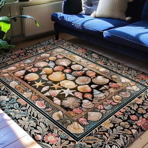 Puede incluir: Alfombra rectangular con un diseño central de conchas marinas y estrellas de mar sobre un fondo negro. La alfombra tiene un borde floral en tonos rosa, azul y naranja. El texto "INK & SHADOW Original Fine Art Rugs" está en la parte inferior.