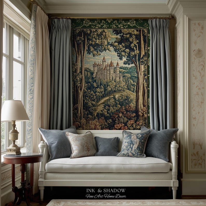 May include: A white daybed with five decorative pillows sits beneath a large wall tapestry depicting a castle in a forest. The tapestry features green, brown, and tan tones. The text "INK & SHADOW Fine Art Home Decor" is printed at the bottom.