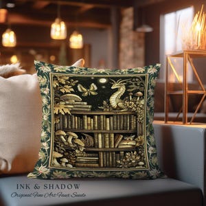 May include: A green and gold pillow with a dragon perched on a bookshelf filled with books. The bookshelf is surrounded by greenery and mushrooms. The pillow has the text "INK & SHADOW Original Fine Art Faux Suede" at the bottom.