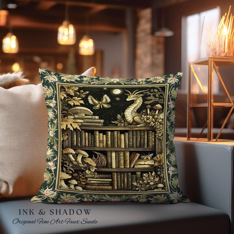 May include: A green and gold pillow with a dragon perched on a bookshelf filled with books. The bookshelf is surrounded by greenery and mushrooms. The pillow has the text "INK & SHADOW Original Fine Art Faux Suede" at the bottom.