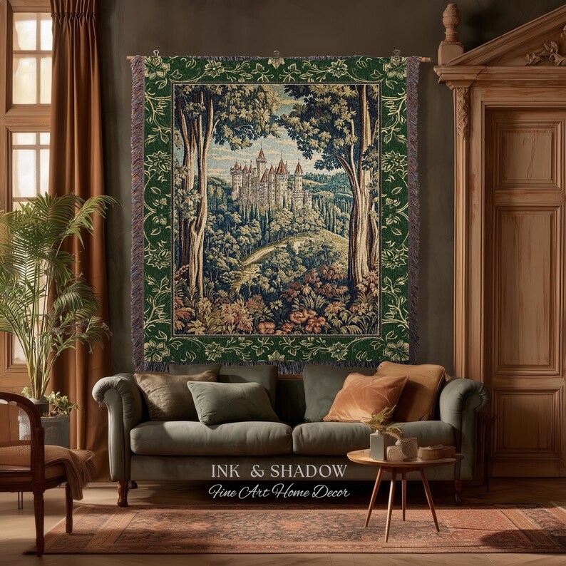 May include: A rectangular woven tapestry featuring a detailed landscape scene of a castle nestled among trees and rolling hills. The tapestry has a dark green border with a floral pattern and is hung on a wooden rod with fringe edges.