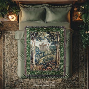 May include: A woven throw blanket featuring a detailed tapestry-style scene of a castle nestled within a dense forest. The blanket has a dark green border with floral patterns and fringed edges, displaying a landscape with trees and a castle.