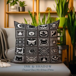 May include: A black and white woven pillow with a Halloween theme. The pillow features a variety of spooky and whimsical designs, including bats, ghosts, cats, spiders, and pumpkins. The pillow is made of a soft, comfortable fabric and is perfect for adding a touch of Halloween spirit to your home decor. The pillow has the text "INK & SHADOW Original Fine Art Woven Pillow" printed on the bottom.