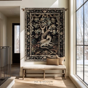 May include: A rectangular wall tapestry featuring a central illustration of a light-colored dragon resting beneath a large tree, surrounded by floral motifs on a black background, framed by a decorative border, hanging from a metal rod.