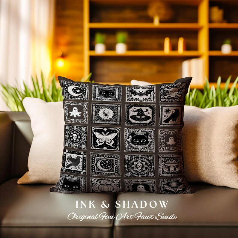 May include: Black and white pillow with a patchwork design featuring various Halloween-themed illustrations, including cats, bats, ghosts, spiders, and moons. The pillow is made of faux suede and has the text "Ink & Shadow Original Fine Art Faux Suede" printed on the bottom.