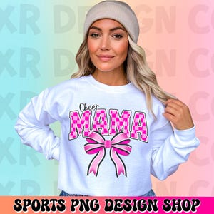 May include: White sweatshirt with the text "Cheer Mama" in pink and black checkered letters with a pink bow.