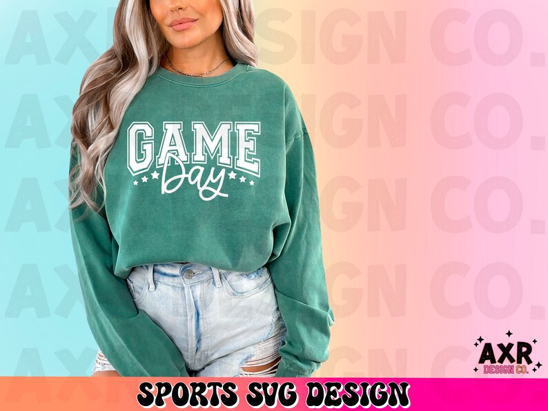 May include: A green sweatshirt with the text "GAME Day" in white lettering. The sweatshirt is being worn by a person with long brown hair.