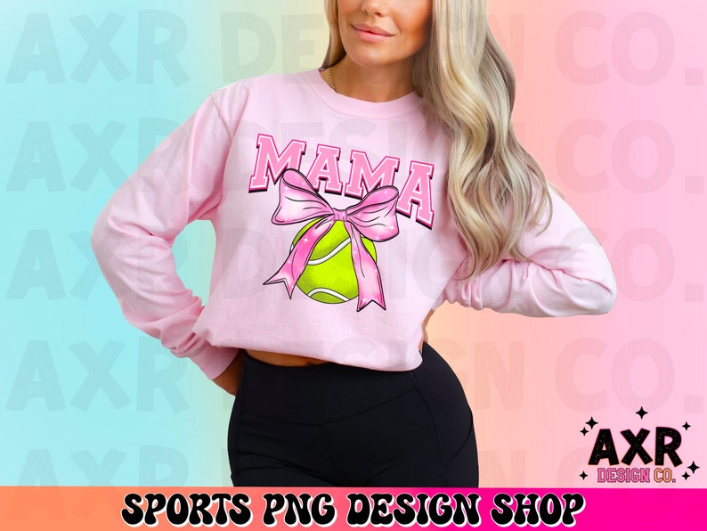 May include: Pink long-sleeved shirt with the word "MAMA" in a white outline and a pink bow with a green tennis ball in the center.