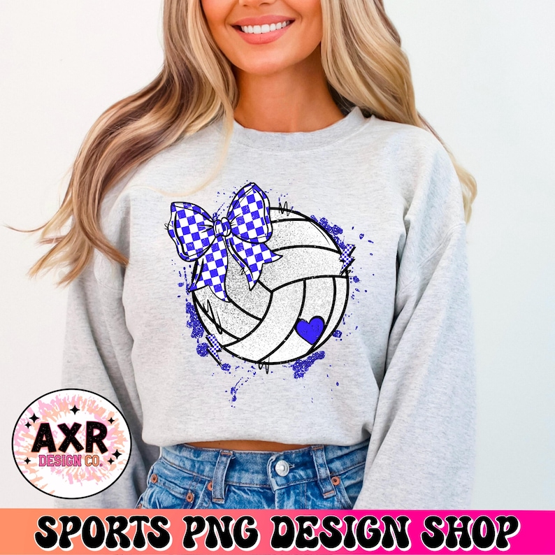 Op de afbeelding: Een grijs sweatshirt met een witte volleybal met een blauw-wit geblokt strikje erop. De volleybal is omringd door blauwe verfspatten.