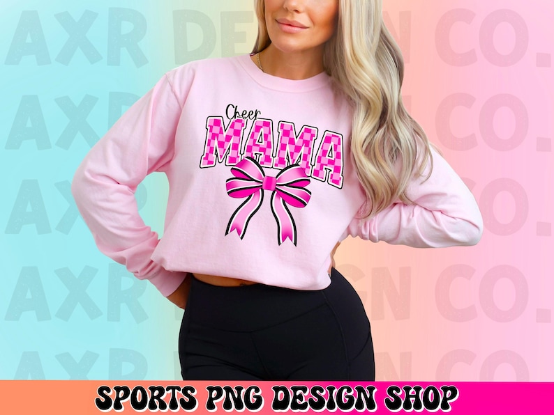 May include: Pink long-sleeved shirt with the text "Cheer Mama" in pink and white checkered letters with a pink bow.