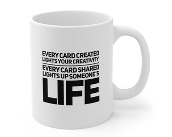 May include: White ceramic coffee mug with black text that reads "Every card created lights your creativity. Every card shared lights up someone's life."
