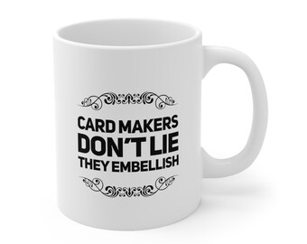 May include: White ceramic coffee mug with black text that reads "Card Makers Don't Lie They Embellish".