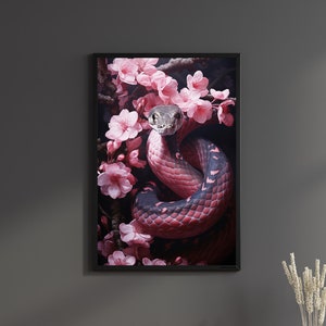 May include: A black framed print of a snake wrapped around pink cherry blossoms. The snake is black and red with a grey head. The background is dark.