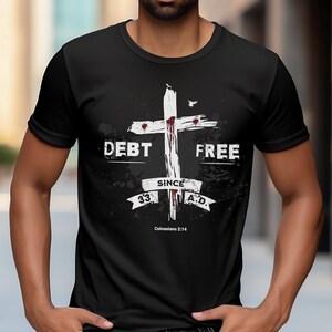 May include: Black t-shirt with a white graphic of a cross with blood drops and the text "DEBT FREE SINCE 33 A.D. Colossians 2:14".