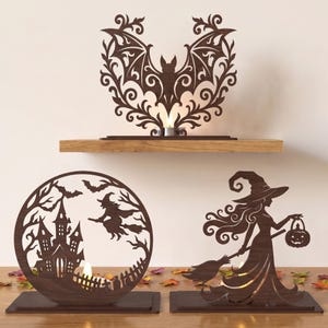 May include: Three dark brown laser-cut wooden decorative displays featuring Halloween themes. One piece shows a bat with ornate scrollwork, another is a circular frame with a haunted house and a witch on a broom, and the third is a witch holding a jack-o'-lantern.