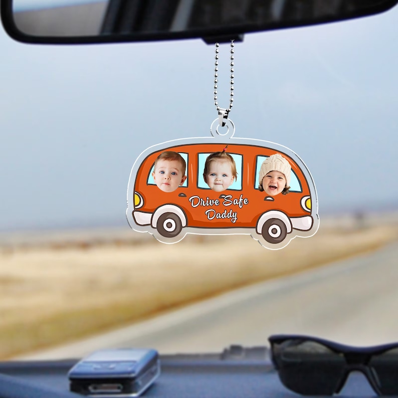 May include: Orange cartoon car rearview mirror charm with three children's faces in the windows. The car has the text "Drive Safe Daddy" on the bottom.