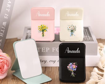 May include: Four decorative cases with floral designs. The cases are in pink, cream, and black, each with the name "Amauda" printed on the top. One case has a bouquet of yellow flowers, another has white flowers, and the last has a colorful bouquet.