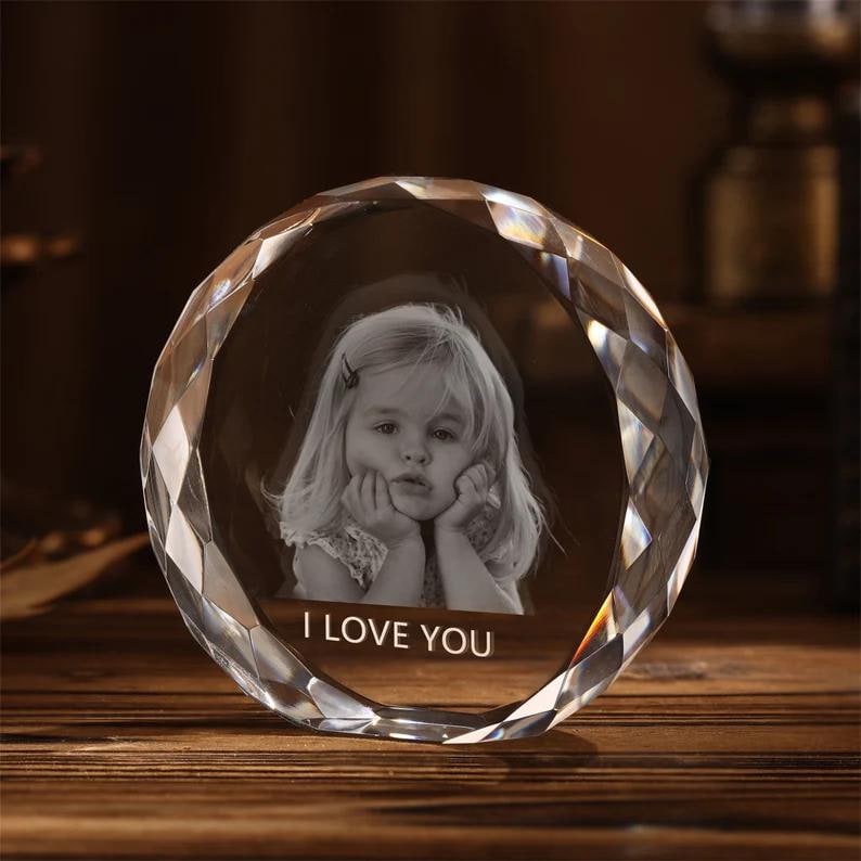 May include: A clear crystal paperweight with a faceted design. The paperweight has a 3D engraved image of a young girl with the text "I LOVE YOU" below the image.