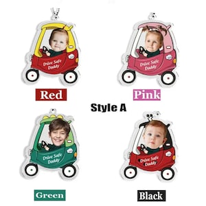 May include: Four different colored car-shaped acrylic ornaments with a photo frame in the front. The ornaments are red, pink, green, and black. Each ornament has the text "Drive Safe Daddy" printed on the front.
