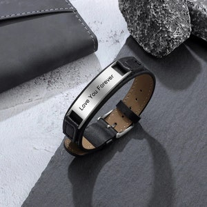 May include: Black leather bracelet with a silver metal plate engraved with the words "Love You Forever".