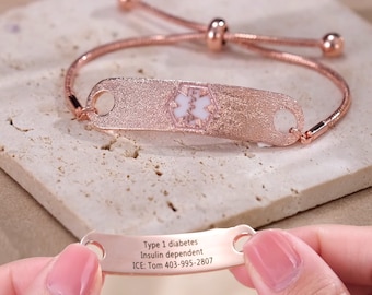 May include: Rose gold medical alert bracelet with a star of life charm and a personalized inscription that reads "Type 1 diabetes Insulin dependent ICE: Tom 403-995-2807".