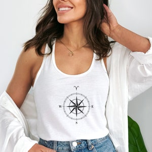 Könnte beinhalten: Ein weißes Tanktop mit einem schwarzen Kompass-Design und dem astrologischen Symbol für Widder. Der Kompass zeigt nach Norden, Süden, Osten und Westen.