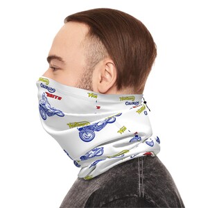 May include: A white neck gaiter featuring a repeating pattern of blue and yellow motorcycle illustrations, the text "Colorado" in blue, "BRITS" in red, and "Northern" in yellow. The fabric accessory includes an adjustable black drawstring cord.