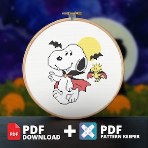May include: A cross-stitch pattern in a wooden hoop featuring a white dog with fangs and a red cape, a yellow bird with a red cape, a yellow moon, and black bats. The design includes text indicating a PDF download and a PDF pattern keeper file.