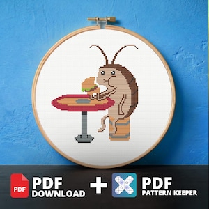 May include: Cross-stitch embroidery in a wooden hoop features a cartoon cockroach eating a hamburger at a table. The cockroach is brown with a segmented body and long antennae. The table is red with a gray base. The text "PDF DOWNLOAD + PDF PATTERN KEEPER" is at the bottom.