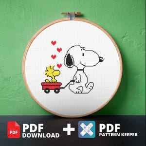 May include: A cross-stitch pattern in a wooden embroidery hoop featuring a white dog with black ears and a yellow bird sitting in a red wagon. Four small red hearts are stitched above the bird. The design is presented as a digital PDF download.