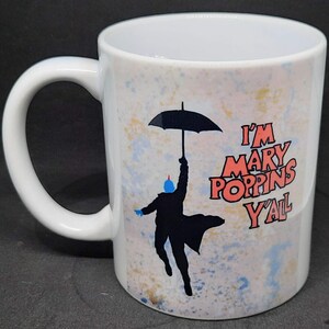 May include: White ceramic coffee mug with a colorful design featuring a silhouette of a person holding an umbrella and the text "I'm Mary Poppins Y'all".