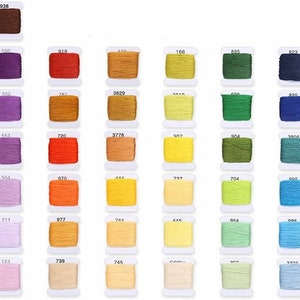 May include: A collection of 100 spools of embroidery floss in various colors, arranged in rows on a white background. Each spool is labeled with a number.