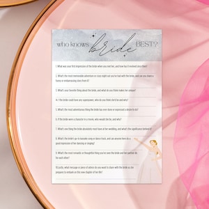 May include: A light blue and white card with the text "Who knows bride best?" and a list of questions about the bride. The card features a silhouette of a bride in a white dress.