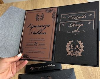 Könnte beinhalten: Eine schwarze und roségoldene Hochzeitseinladung mit den Namen Esperanza und Ashton, dem Datum 24. August 2024 und den Initialen EA in einem Kranz.