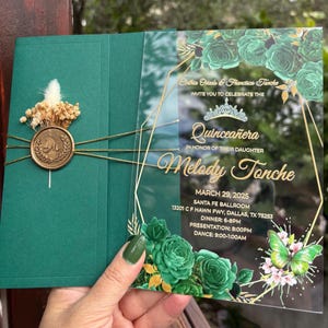 Convite de acrílico para festa de 15 anos com tema de rosas verdes e borboletas. Meio envelope verde, lacre de cera personalizado e flores secas.