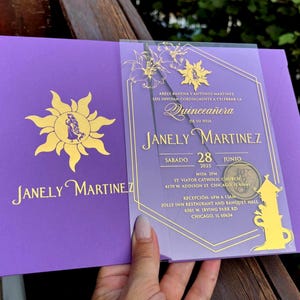 Puede incluir: Invitación de quinceañera morada con detalles dorados. La invitación presenta el nombre "Janely Martinez" y los detalles del evento. El diseño incluye un sol y elementos florales, con texto en inglés y español.