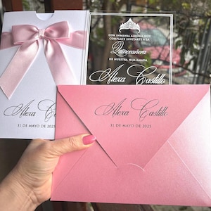 Invito per la festa della Quinceañera in acrilico con nastro, busta bianco perla con nastro rosa, busta postale stampata rosa perla.