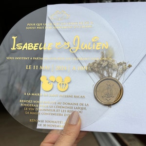 Invito di nozze in acrilico a tema Disney, taglio rotondo, con busta bianca perlata, sigillo di ceralacca personalizzato e fiori secchi.
